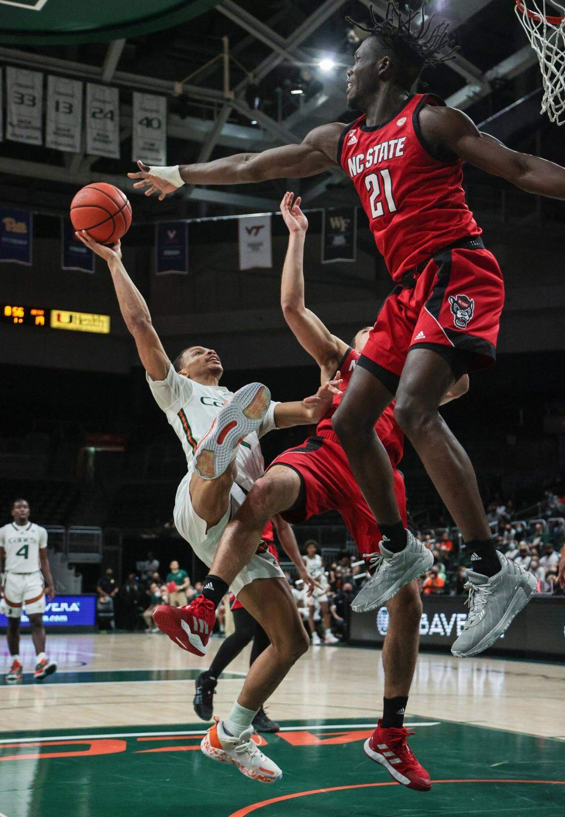 Miami Hurricanes guard Isaiah Wong (2) battles North Carolina State Wolfpack as he attempts a basket in the first half at the Watsco Center in Coral Gables on Wednesday, December 29, 2021.