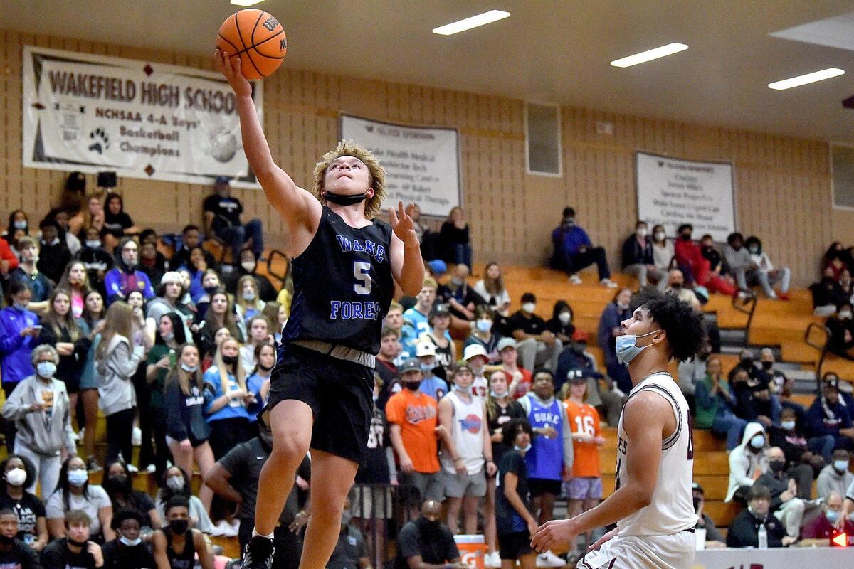 Wake Forest’s A.J. Smalls (5) makes the layup against Wakefield’s Jaxon Brown (24) during the second half. The Wake Forest Cougars and the Wakefield Wolverines met in a conference basketball game in Raleigh, NC on February 4, 2022.