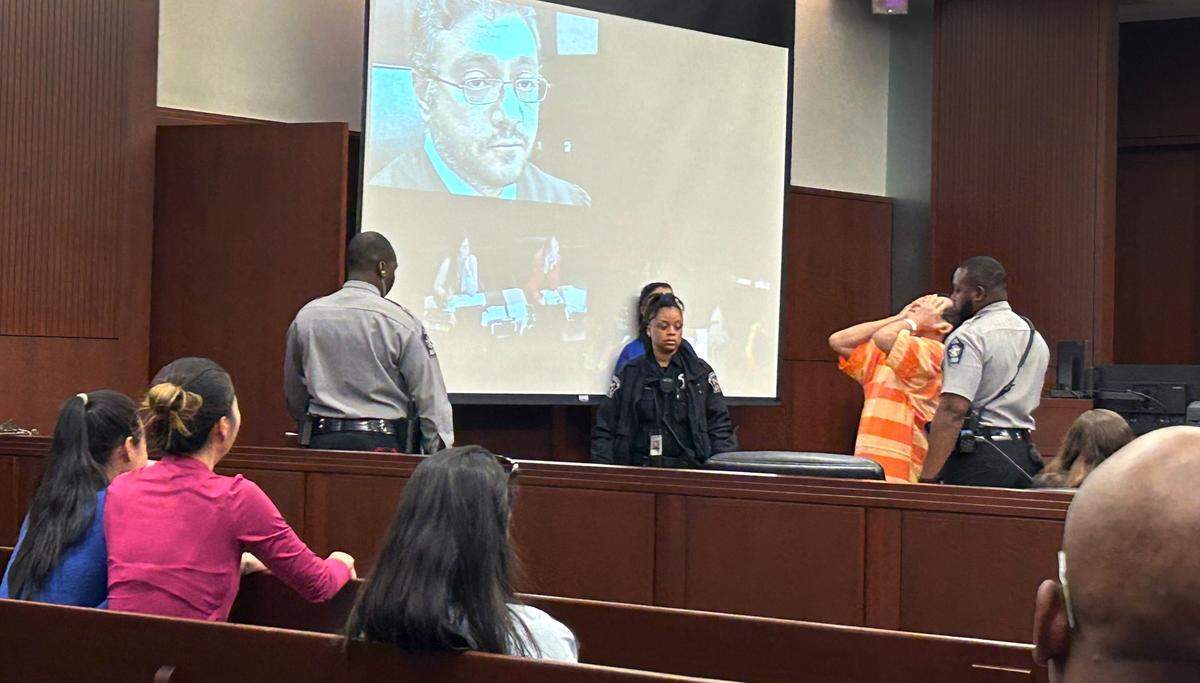 Xuan Thanh Pham, 63, cries in Wake County court with his face in his hands in front of his onlooking family members on Monday, September 18, 2023. He is charged with murder.