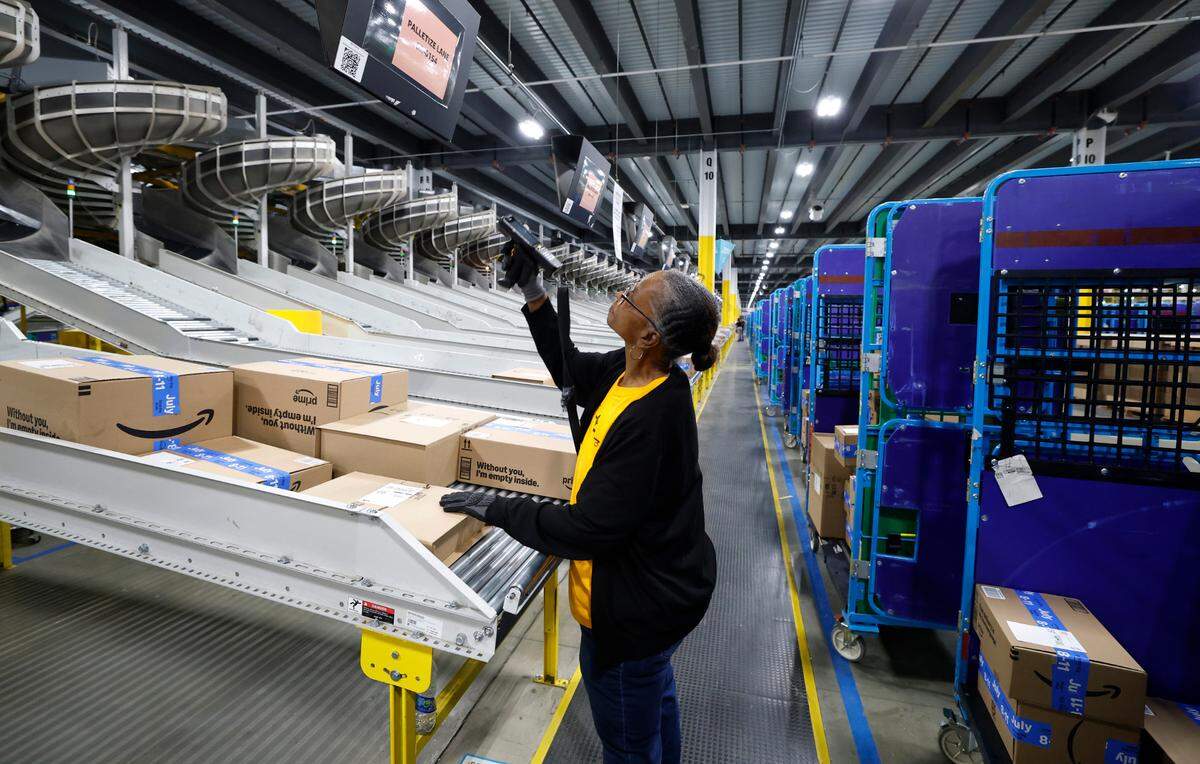 Sandy Urgelles scans packages at RDU1, an Amazon Robotics Fulfillment Center in Garner, N.C., Tuesday, July 1, 2025.