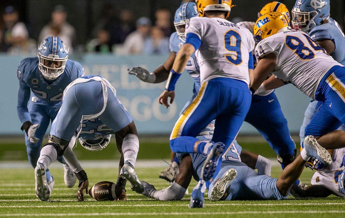 North Carolina’s Power Echols (23) works to recover a fumble by Pitt’s Israel Abanikanda (2) in the fourth quarter. Teammate Cedric Grey (33) forced the fumble and recovered the ball on Saturday, October 29, 2022 at Kenan Stadium in Chapel Hill, N.C.