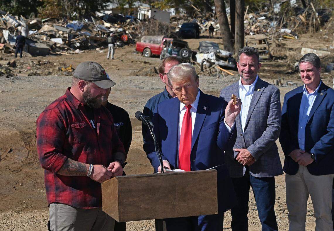 Adam Smith, left, a former Green Beret presents former President Donald J. Trump, right, with a cross memento during the former president’s tour of damage caused in Swannanoa, NC area by Hurricane Helene on Monday, October 21, 2024.