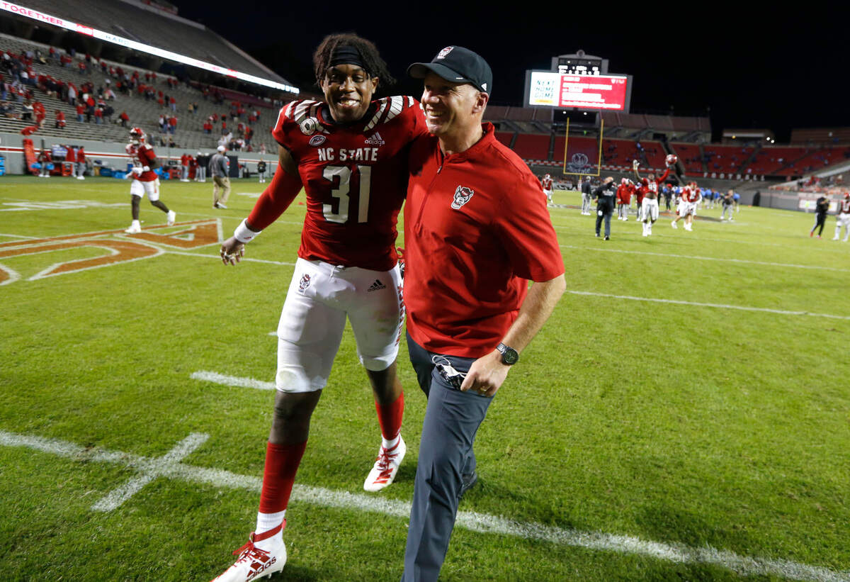 N.C. State head coach Dave Doeren celebrates with Vi Jones (31) as they walk off the field after N.C. State’s 31-20 victory over Duke at Carter-Finley Stadium in Raleigh, N.C., Saturday, Oct. 17, 2020.