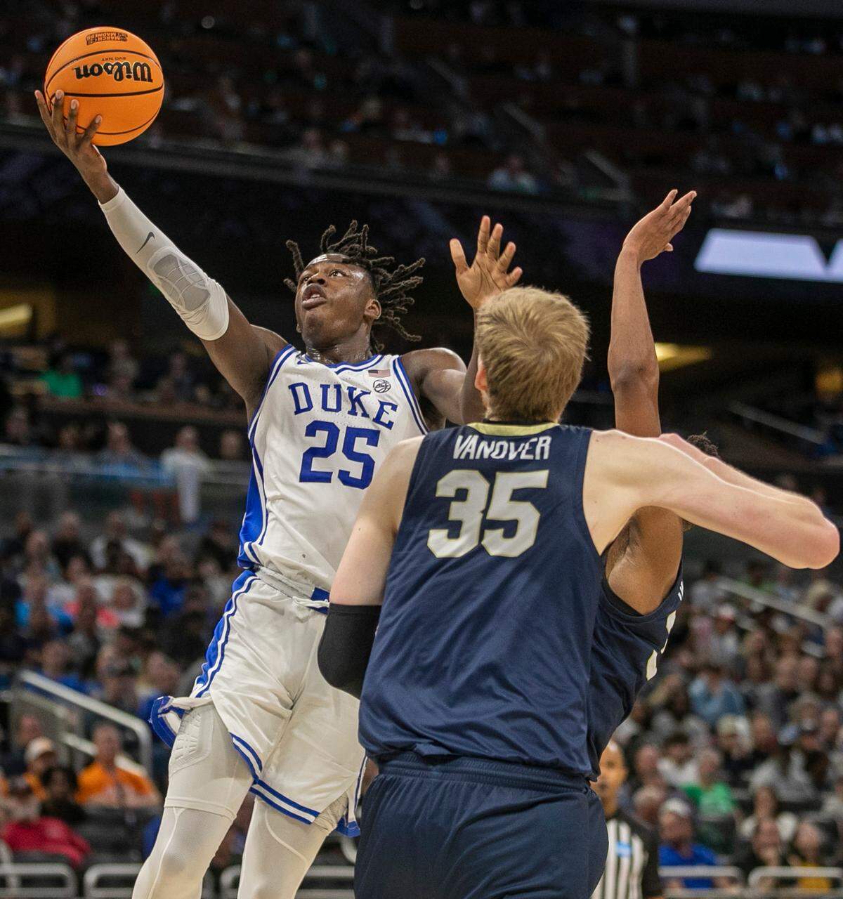 Duke’s Mark Mitchell (25) drives to the basket against Oral Roberts’ Patrick Mwamba (32) and Connor Vanover (35) in the second half during the first round of the NCAA Tournament on Thursday, March 16, 2023 at the Amway Center in Orlando, Fla.