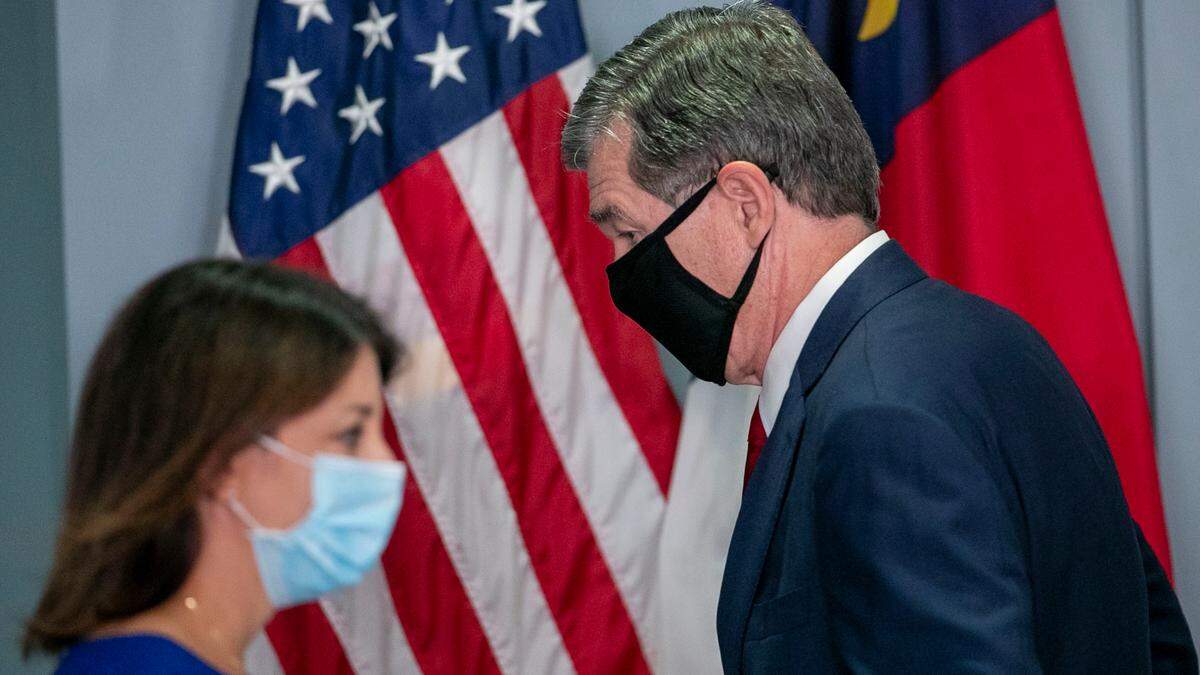 North Carolina Governor Roy Cooper and Dr. Mandy Cohen, Secretary of the North Carolina Department of Health and Human Services, trade places at the podium during a press briefing on the surge of COVID-19 cases on Thursday, September 9, 2021 at the Emergency Operations Center in Raleigh, N.C.