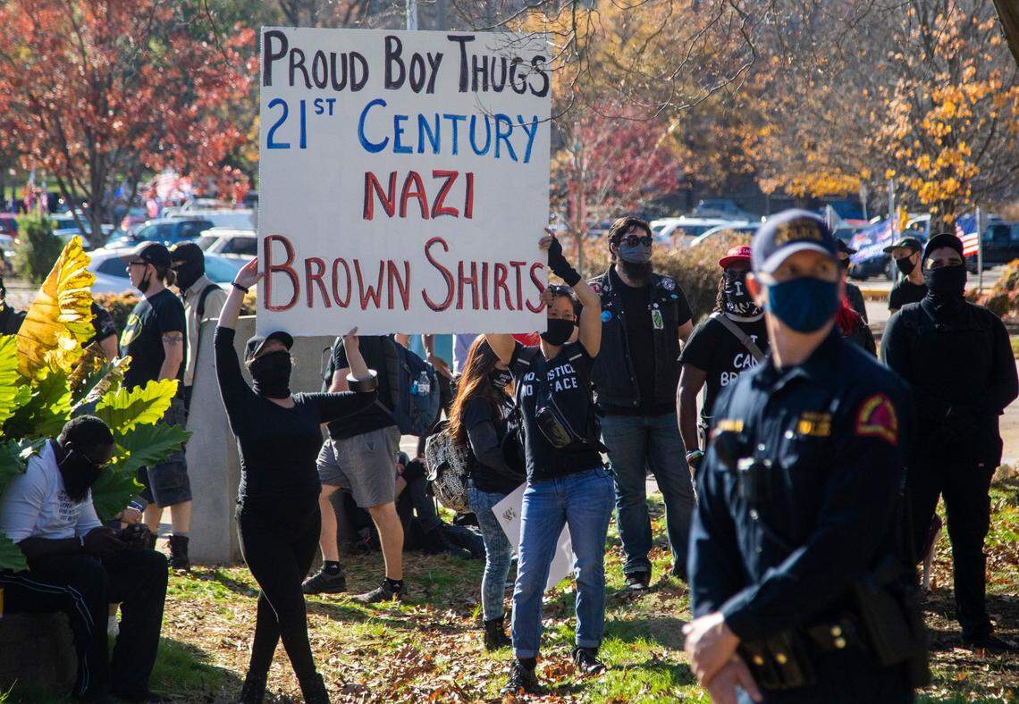 Counter-protesters hold up a sign during a rally in support of President Donald Trump that included members of the Proud Boys Saturday, Nov. 28, 2020 in a downtown Raleigh.