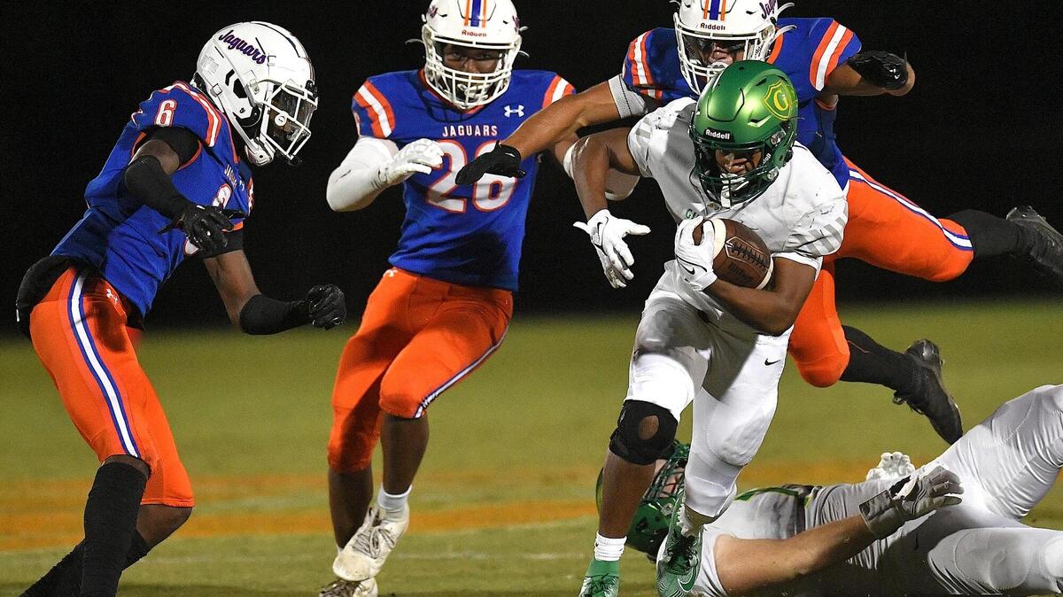 Cardinal Gibbons’ Kendall Scotton (5) runs for the first down against the Athens Drive defense during the first half. The Cardinal Gibbons Crusaders and the Athens Drive Jaguars met in a conference football game in Raleigh , N.C. on September 29, 2023.