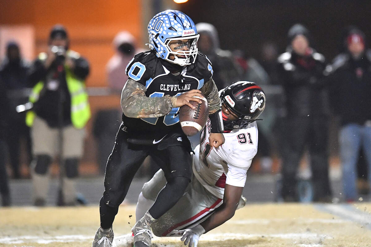 Cleveland quarterback Jackson Byrd (20) scrambles for yards past Rolesville’s Jaden Fry (91) during the second half. The Rolesville Rams and the Cleveland Rams met in the fourth round of the NCHSAA 4A football playoffs in Clayton, N.C. on December 6, 2024.