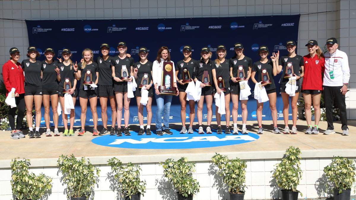 The NC State women’s cross country team poses with the NCAA Championship Trophy after capturing the first NCAA national title in school history.
