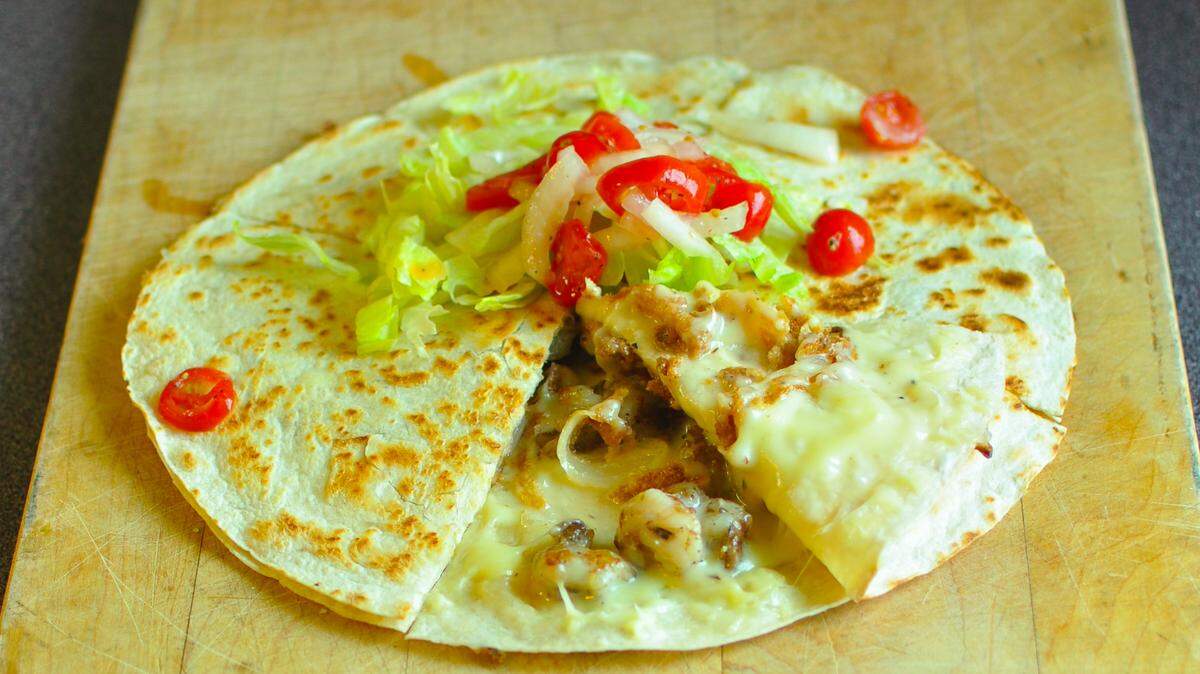 The Jamaican Dilla at ThrillaDilla includes jerk-spiced tuna, American cheese, onions, lettuce, and marinated tomatoes.