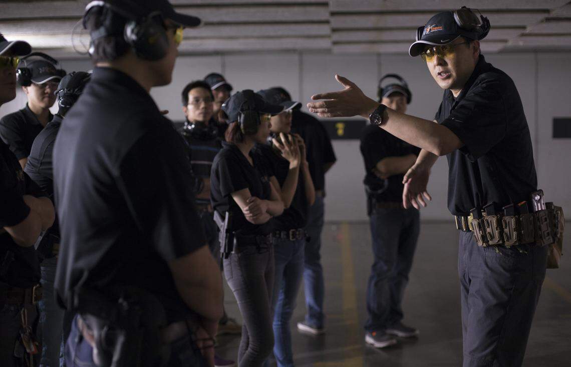 Wei Miao, right, instructs a group of small business owners, members of the N.C. Chinese Hunting Club, at the Wake County Firearms Education & Training Center in Apex, NC on Sunday April 29, 2018. The group, which has grown from 10-15 to around 100 people over two years, feels targeted after many of their peers have been repeatedly robbed at gunpoint.