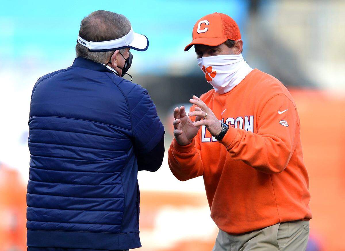 Clemson Tigers head coach Dabo Swinney, right, speaks with Notre Dame head coach Brian Kelly, left, at Bank of America Stadium on Saturday, December 19, 2020 in Charlotte, NC. The Clemson Tigers face the Notre Dame Fighting Irish in the ACC Championship game.