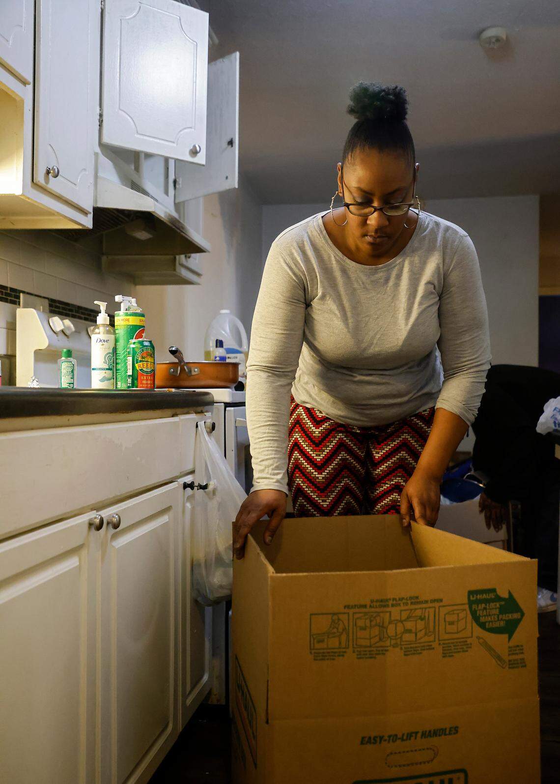 Portia Watson packs a moving box in the kitchen of her apartment in Durham, N.C. on Friday, Dec. 30, 2022. Watson says she received notice that her lease would not be renewed after she took in neighbors from the same complex.