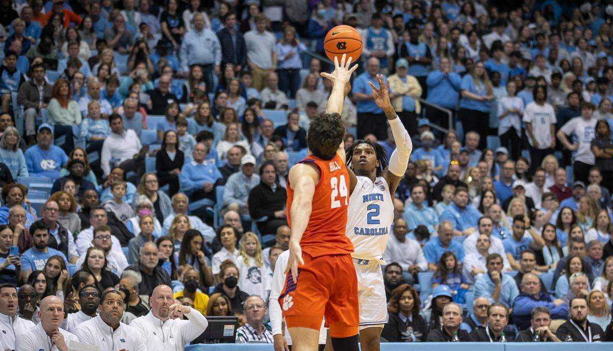North Carolina’s Caleb Love (2) launches a three point shot over Clemson’s P.J. Hall (24) in the second half on Saturday, February 11, 2023 at the Smith Center in Chapel Hill, N.C.