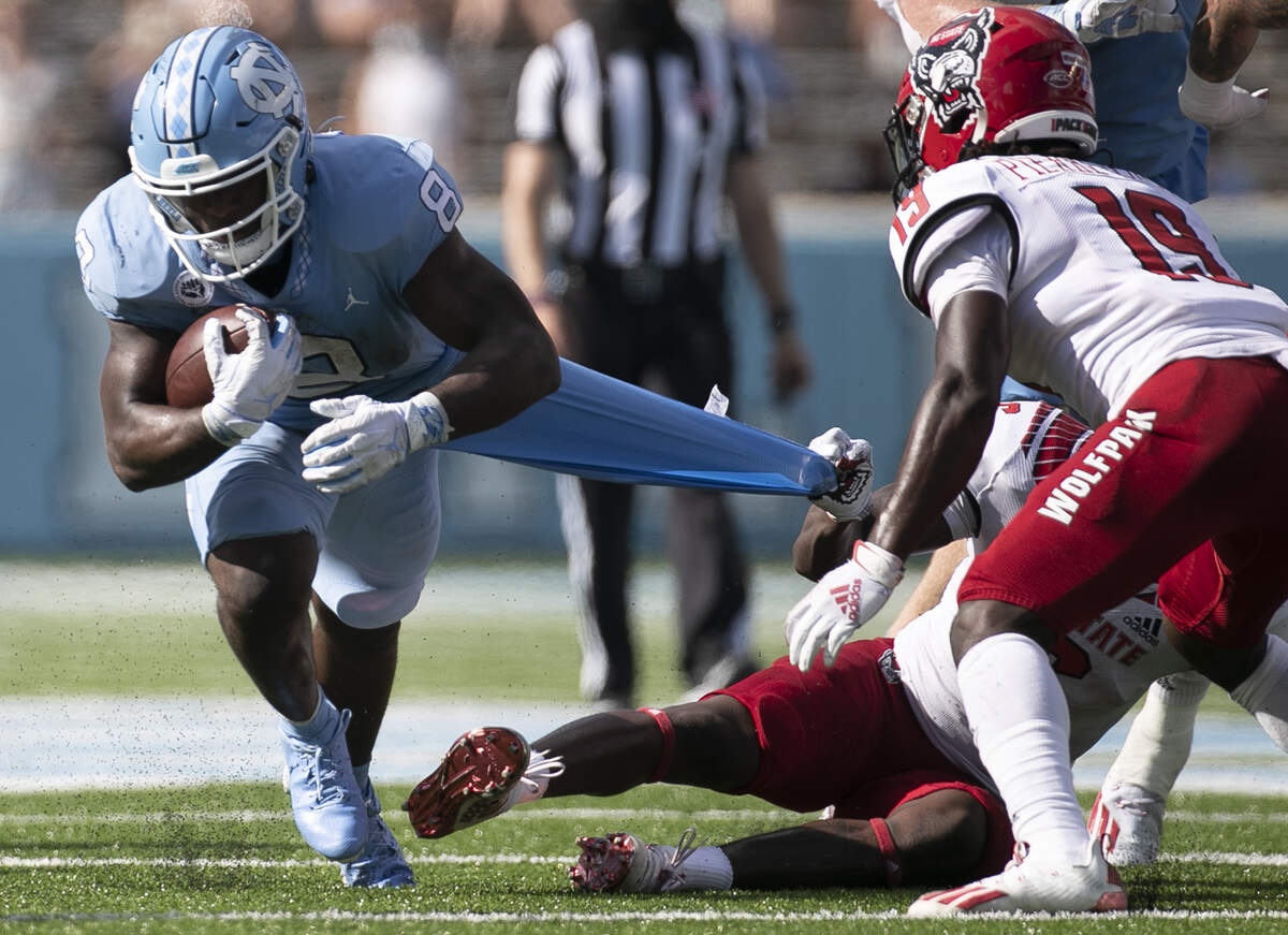 N.C. State’s Jakeen Harris (6) tries to stop North Carolina’s Michael Carter (8) after a 12-yard gain in the third quarter at Kenan Stadium on Saturday, October 24, 2020 in Chapel Hill, N.C.