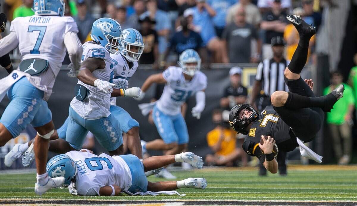 North Carolinas CamRon Kelly (9) flips Appalachian State quarterback Chase Brice (7) after a gain of 10 yards in the fourth quarter on Saturday, September 3, 2022 at Kidd Brewer Stadium in Boone, N.C.