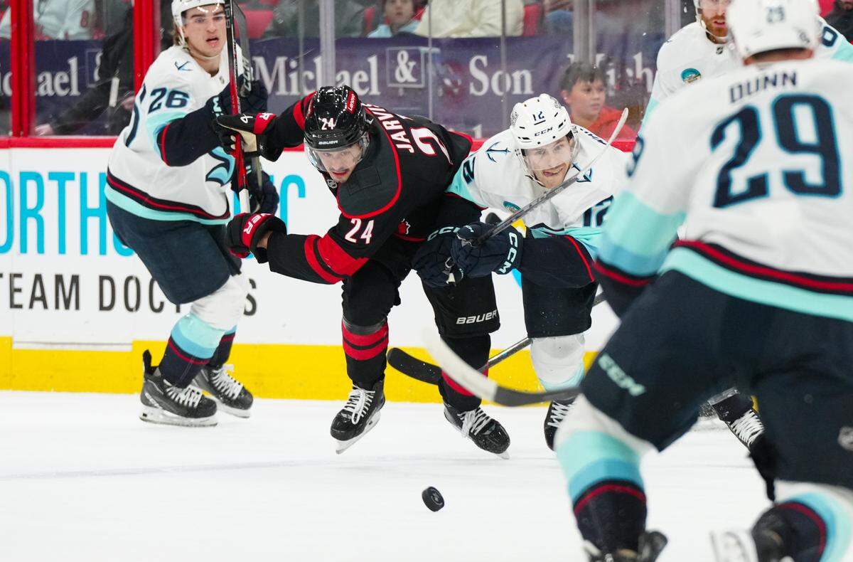 Carolina Hurricanes center Seth Jarvis (24) and Seattle Kraken left wing Tye Kartye (12) battle over the puck during the first period at Lenovo Center.