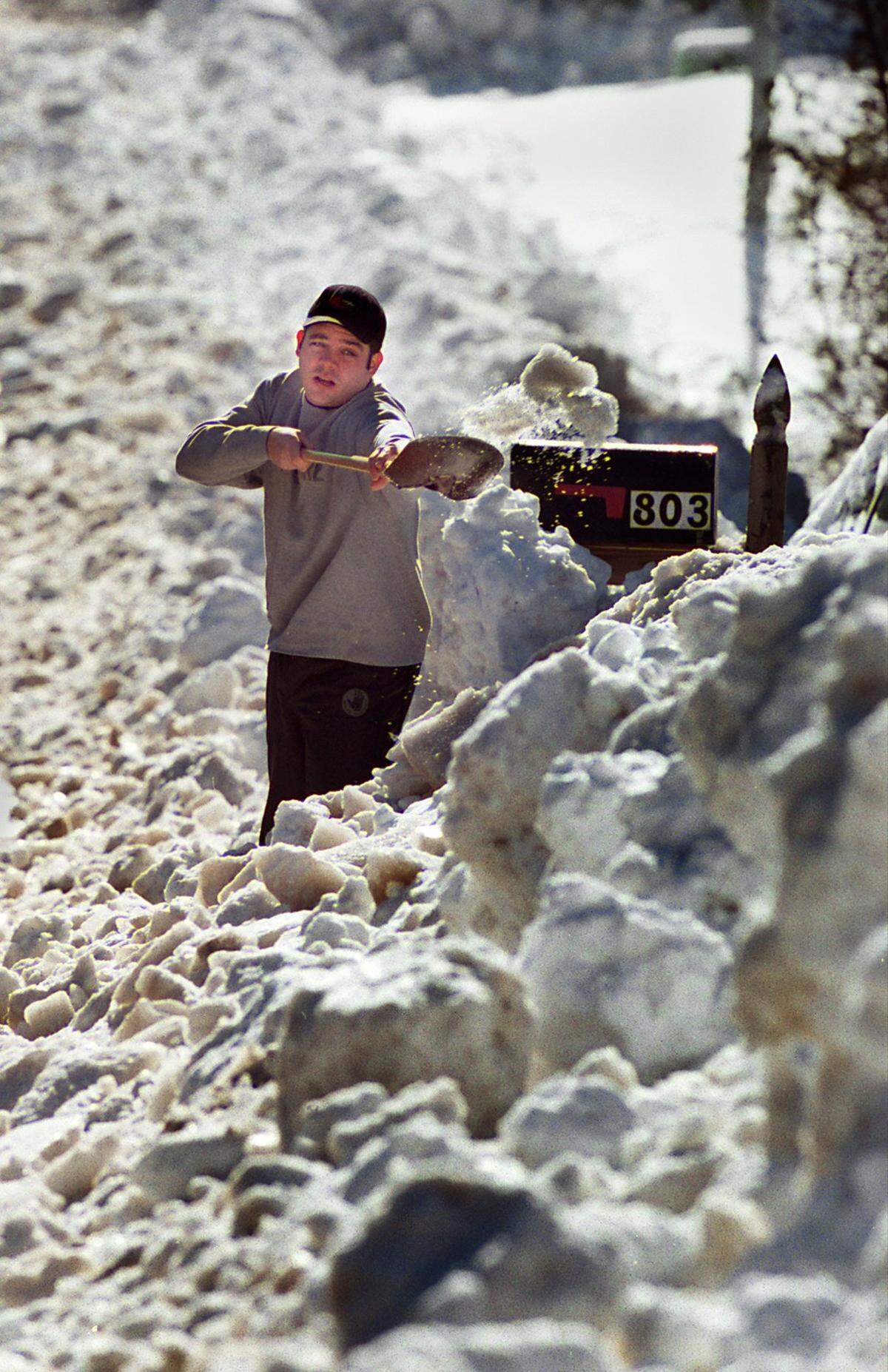 Mike Carlson tries to dig his way through a wall of snow and ice that was plowed in front of his driveway on Maynard Road in Cary in 2000.