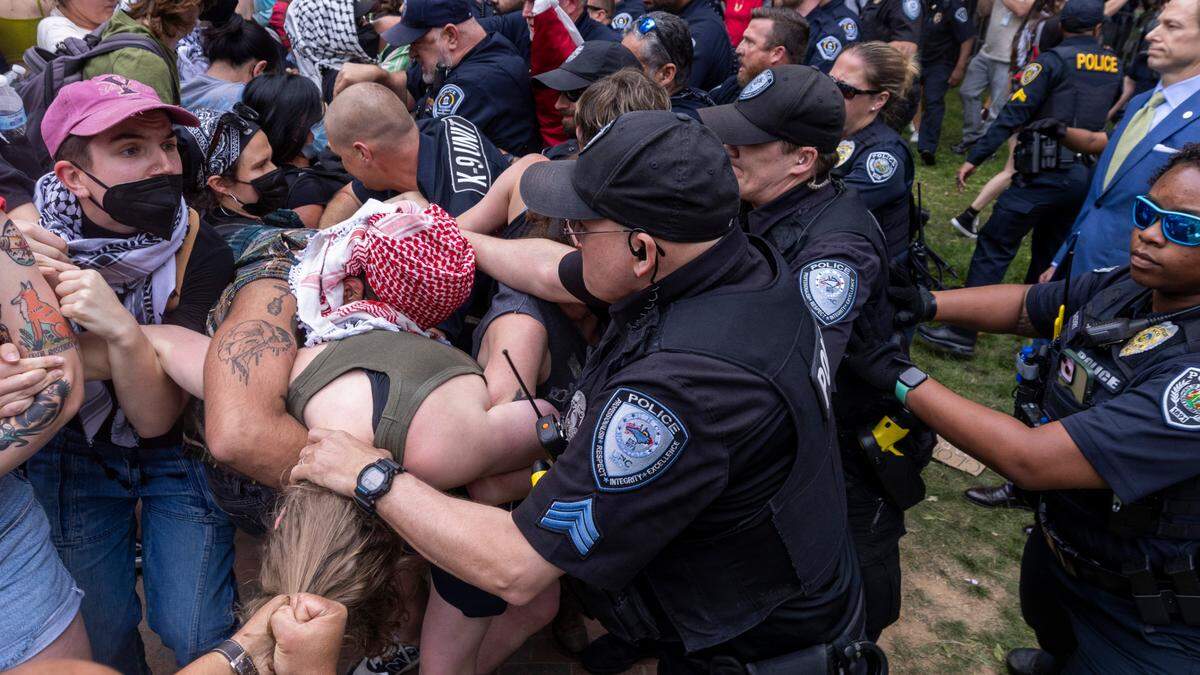 Pro-Palestinian demonstrators clash with police after replacing an American flag with a Palestinian flag Tuesday, April 30, 2024 at UNC-Chapel Hill. Police removed a “Gaza solidarity encampment” earlier Tuesday morning.
