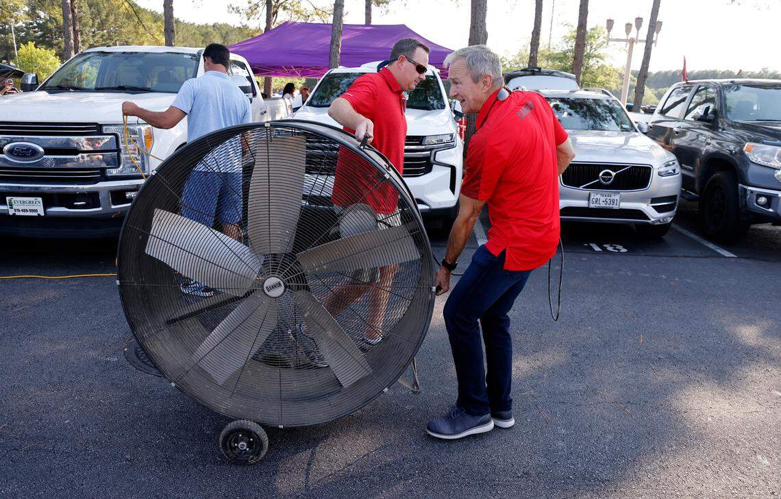 Steve Knier, right, and Brian Burns move a 48-inch shop fan as they set up their tailgate before the Carolina Hurricanes’ playoff game against the N.Y. Rangers at PNC Arena Friday, May 20, 2022.