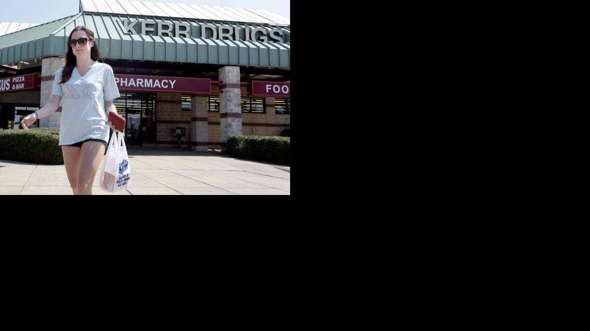 Caitlin Ryan, a senior at N.C. State University, heads out of the Kerr Drugs near campus at Mission Valley on Avent Ferry Road in Raleigh.