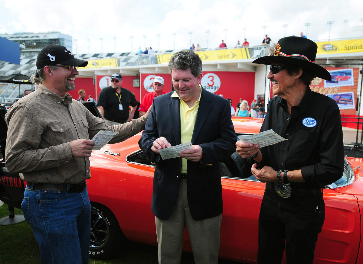 (L-R) Former NASCAR driver Kyle Petty, Postmaster General Pat Donahoe and former NASCAR driver and Hall of Fame member Richard Petty joke following the U.S. Postal Service First-Day-of-Issue dedication ceremony for the new Limited-edition America on the Move: Muscle Cars Forever stamps on Friday, February 22, 2013 at Daytona International Speedway. Jeff Siner - jsiner@charlotteobserver.com