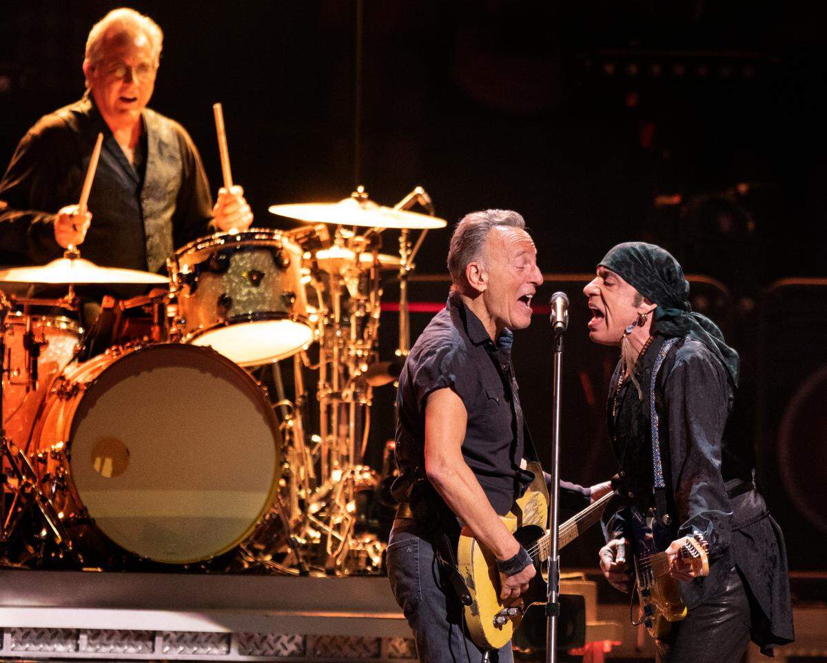 Bruce Springsteen and Steven Van Zand meet at the mic as drummer Max Weinberg pounds the skins on “No Surrender” at the Greensboro Coliseum Saturday night, March 25, 2023.