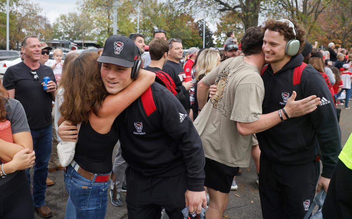 N.C. State linebacker Drake Thomas, left, and his brother, wide receiver Thayer Thomas, are hugged by friends and family during the Walk of Champions before N.C. State’s game against Boston College at Carter-Finley Stadium in Raleigh, N.C., Saturday, Nov. 12, 2022.