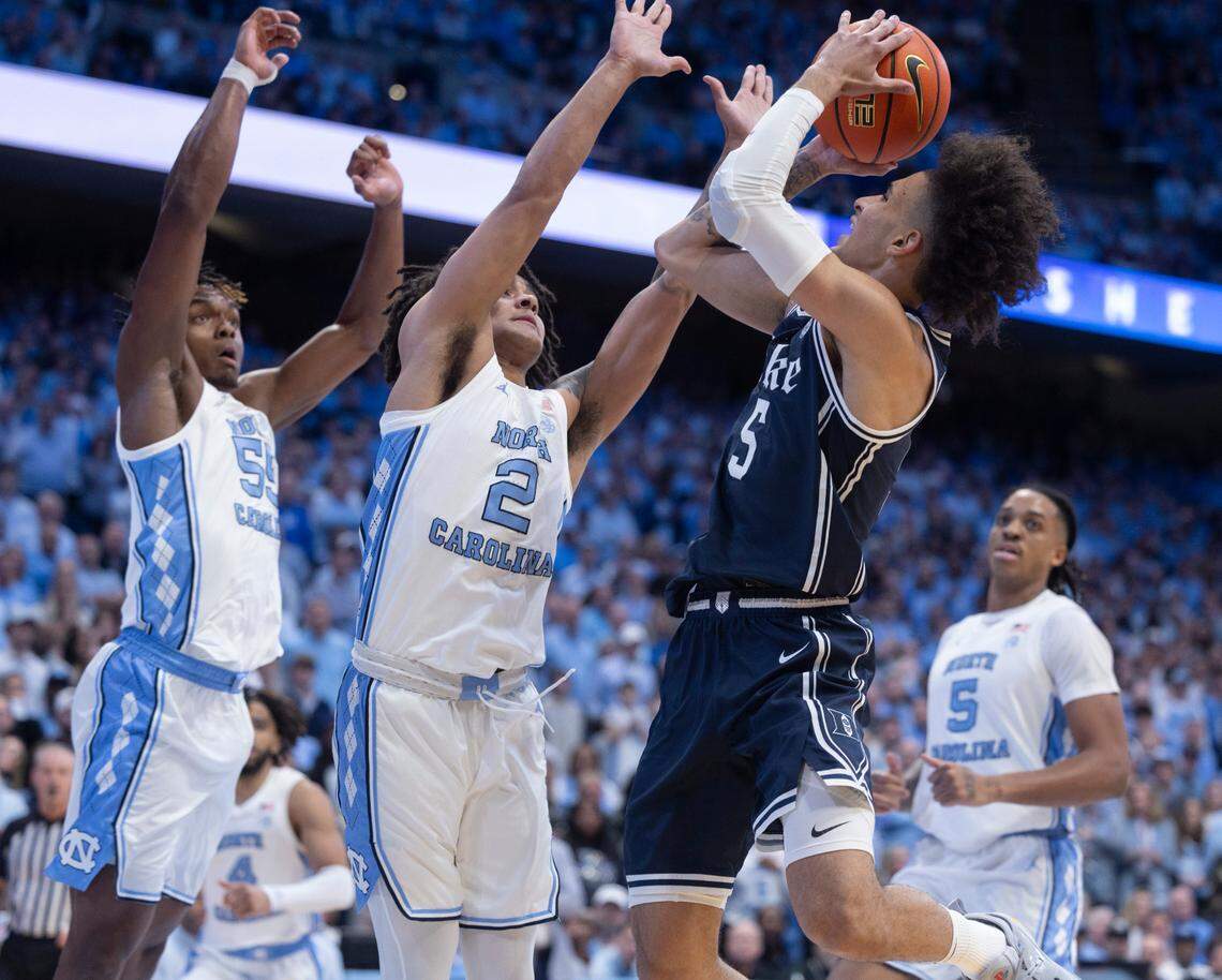 North Carolina’s Harrison Ingram (55) and Elliot Cadeau (2) defend Duke’s Tyrese Proctor (5) in the first half on Saturday, February, 3, 2024 at the Dean E. Smith Center in Chapel Hill, N.C.