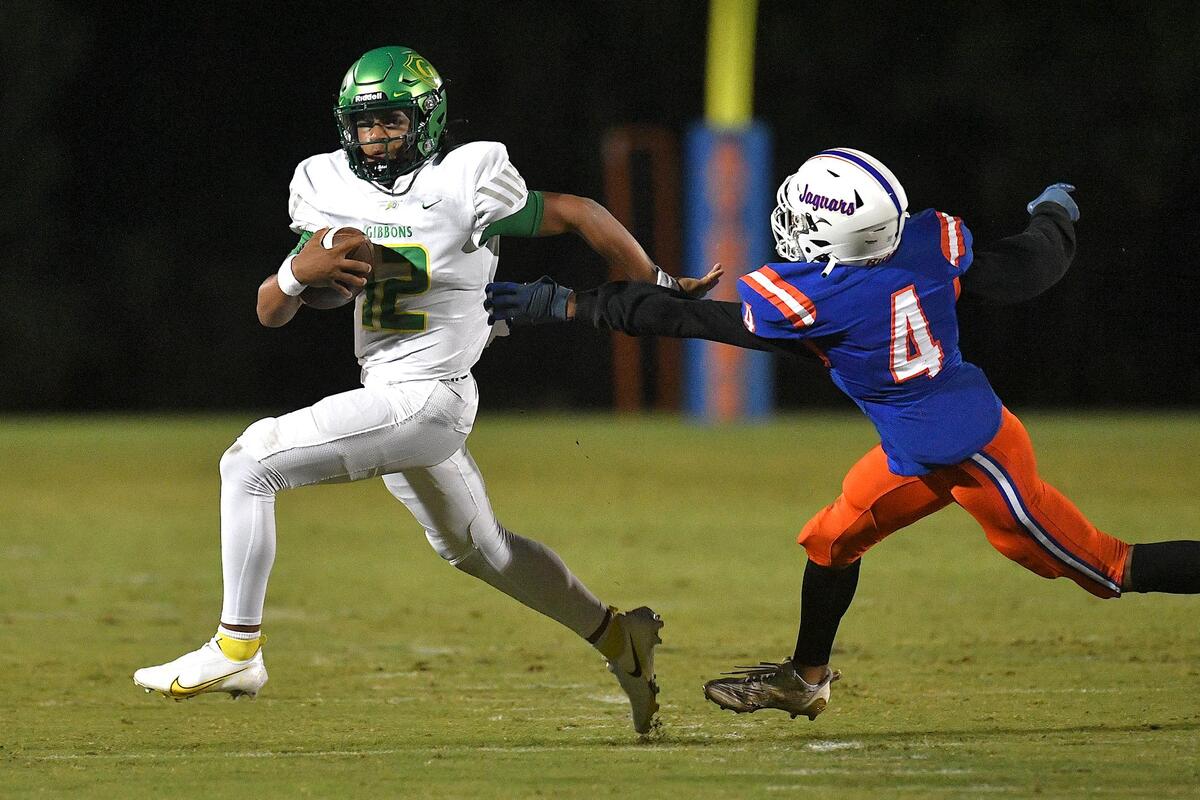 Cardinal Gibbons’ Gannon Jones (12) runs for yardage against Athens Drive’s Jahsiah Battle (4) during the first half. The Cardinal Gibbons Crusaders and the Athens Drive Jaguars met in a conference football game in Raleigh , N.C. on September 29, 2023.