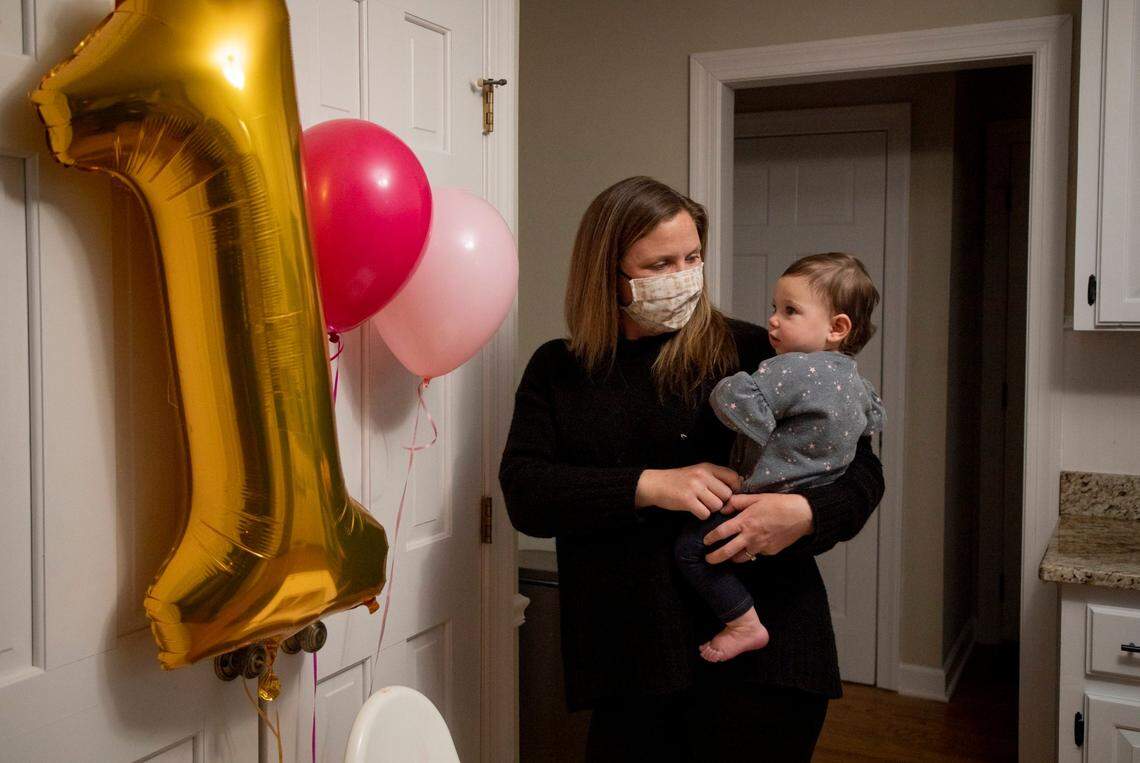 Julia Casadonte, left, holds her daughter Lily while celebrating her first birthday which falls on the day before the anniversary of North CarolinaÕs first public case of COVID-19, on Tuesday, Mar. 2, 2021, in Cary, N.C.