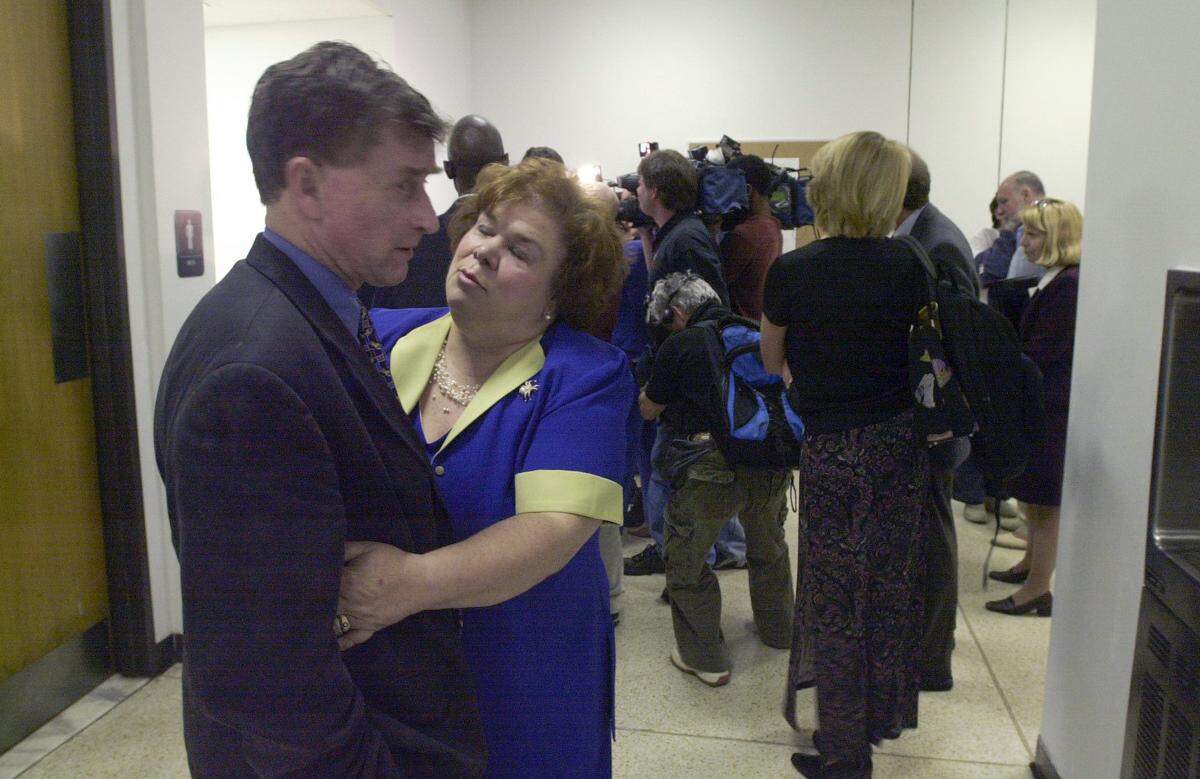 Michael Peterson is comforted by a supporter during a break in a hearing April 30, 2003.