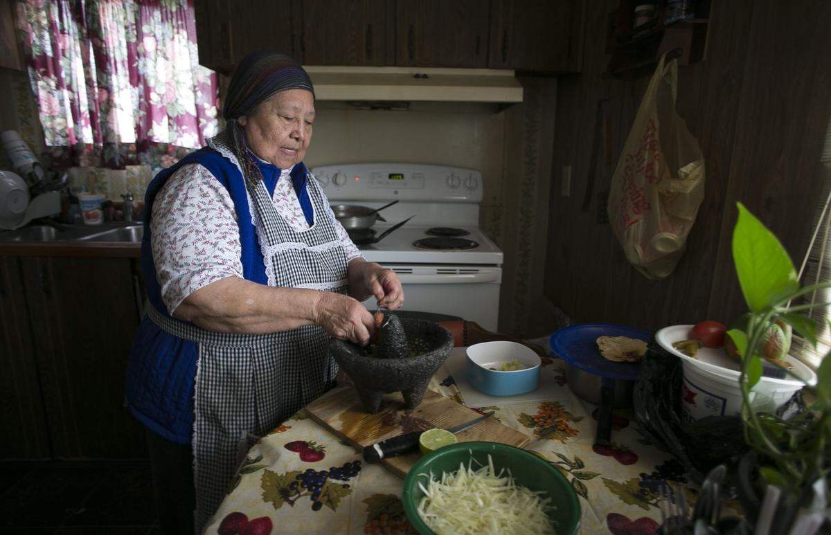 Natalia Lopez, age 72, prepares lunch in the kitchen of her home at Johnson’s Mobile Home Park in Siler City, N.C. Lopez and her husband have lived here for more than 25 years.