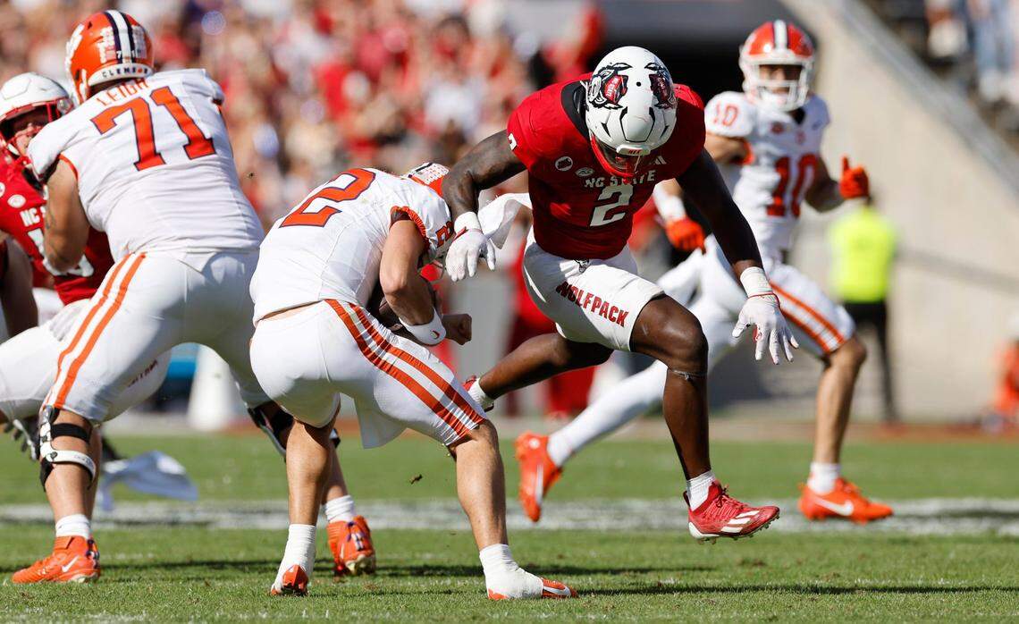 Clemson quarterback Cade Klubnik (2) escapes the sack attempt by linebacker Jaylon Scott (2) during the first half of N.C. State’s game against Clemson at Carter-Finley Stadium in Raleigh, N.C., Saturday, Oct. 28, 2023.