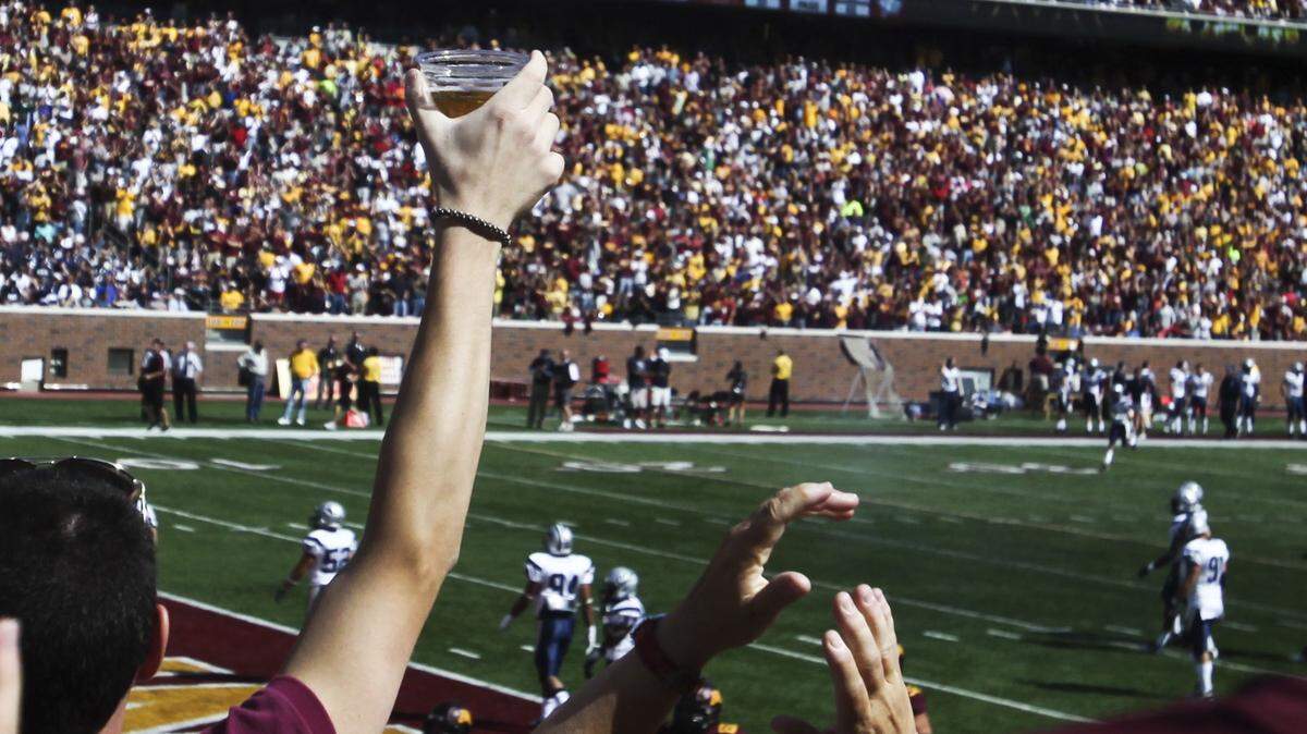 In this Sept. 8, 2012, photo, a fan hoists a beer during a college football game between Minnesota and New Hampshire at TCF Bank Stadium in Minneapolis, Minn.
