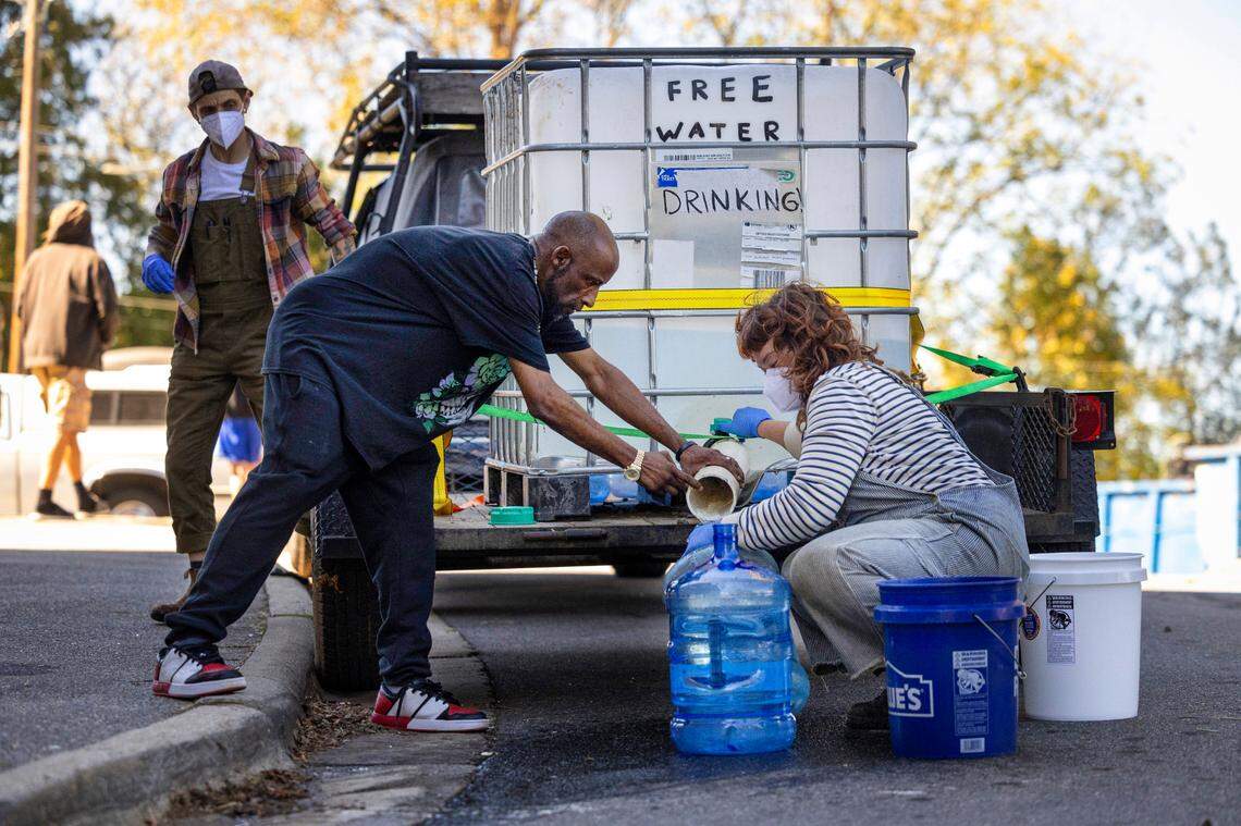 Volunteers with the grassroots group BeLoved Asheville, fill bottles of drinking water for residents in low-income independent living facilities, with no running water on Wednesday, October. 8, 2024. About half of Asheville’s water customers were still without running water this week because the remnants of Hurricane Helene ripped apart the city’s distribution system.