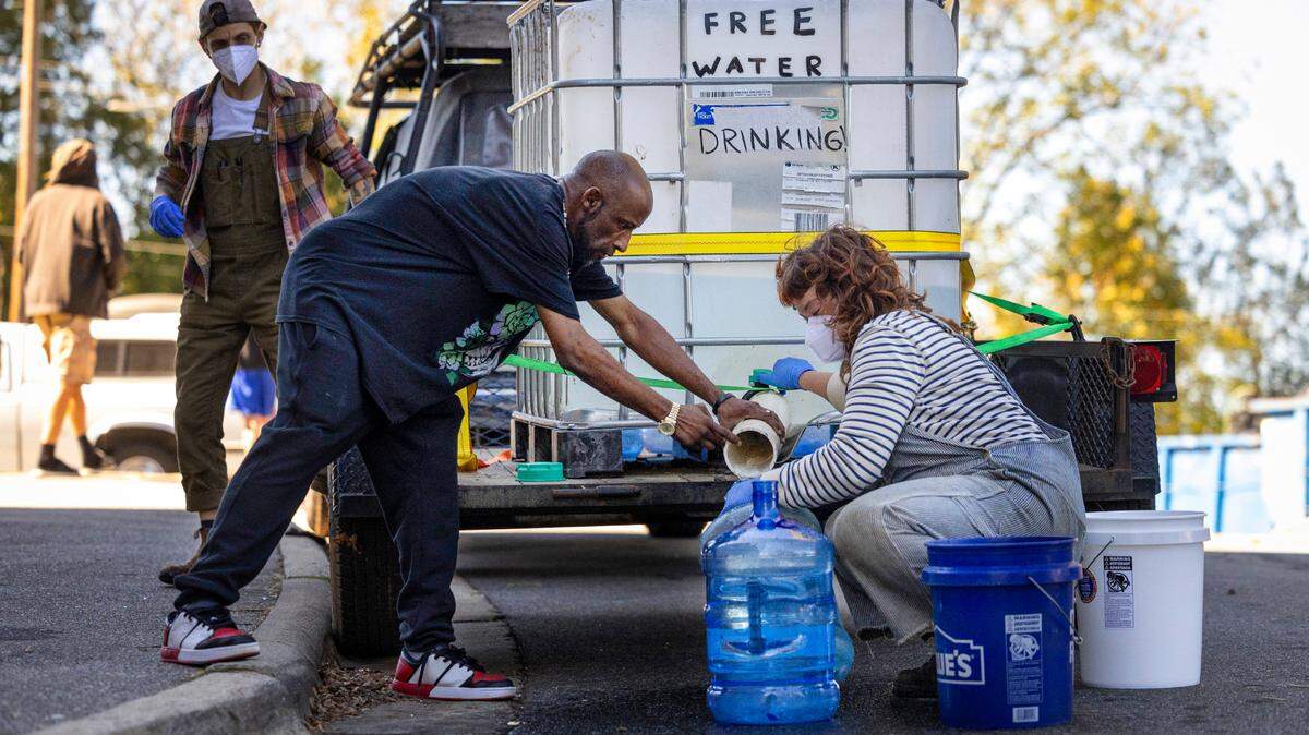 Volunteers in Asheville fill bottles of drinking water for residents in independent living facilities with no running water on Oct. 8. Now Asheville residents have water coming from their taps - but it’s not safe to drink. City officials are trying to fix that.