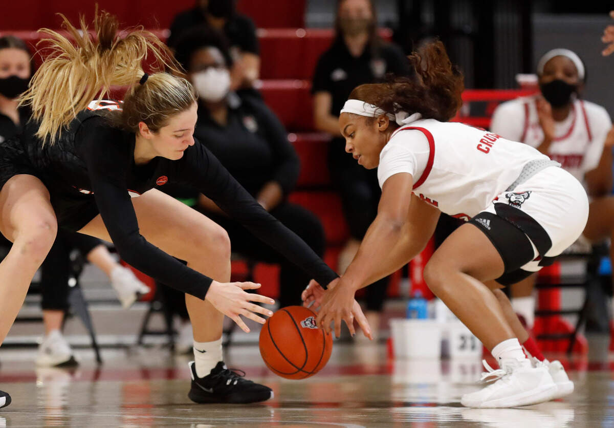 Virginia Tech’s Elizabeth Kitley (33) and N.C. State’s Kai Crutchfield (3), right, go after the loose ball during the first half of N.C. State’s game against Virginia Tech at Reynolds Coliseum in Raleigh, N.C., Sunday, January 24, 2021.