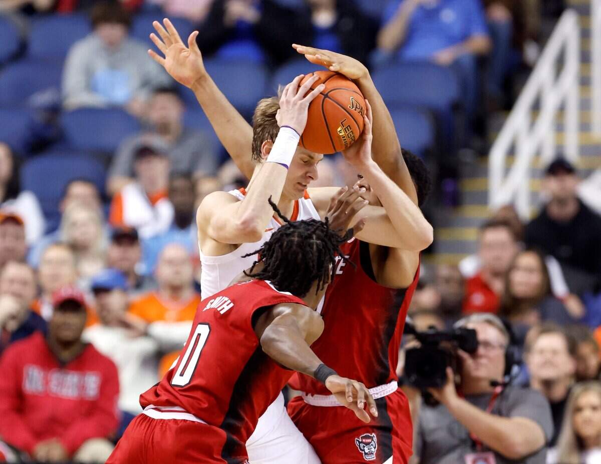 N.C. State’s Casey Morsell (14) and Terquavion Smith (0) pressure Clemson’s Hunter Tyson (5) during the first half of N.C. State’s game against Clemson in the quarterfinals of the ACC Men’s Basketball Tournament in Greensboro, N.C., Thursday, March 9, 2023.