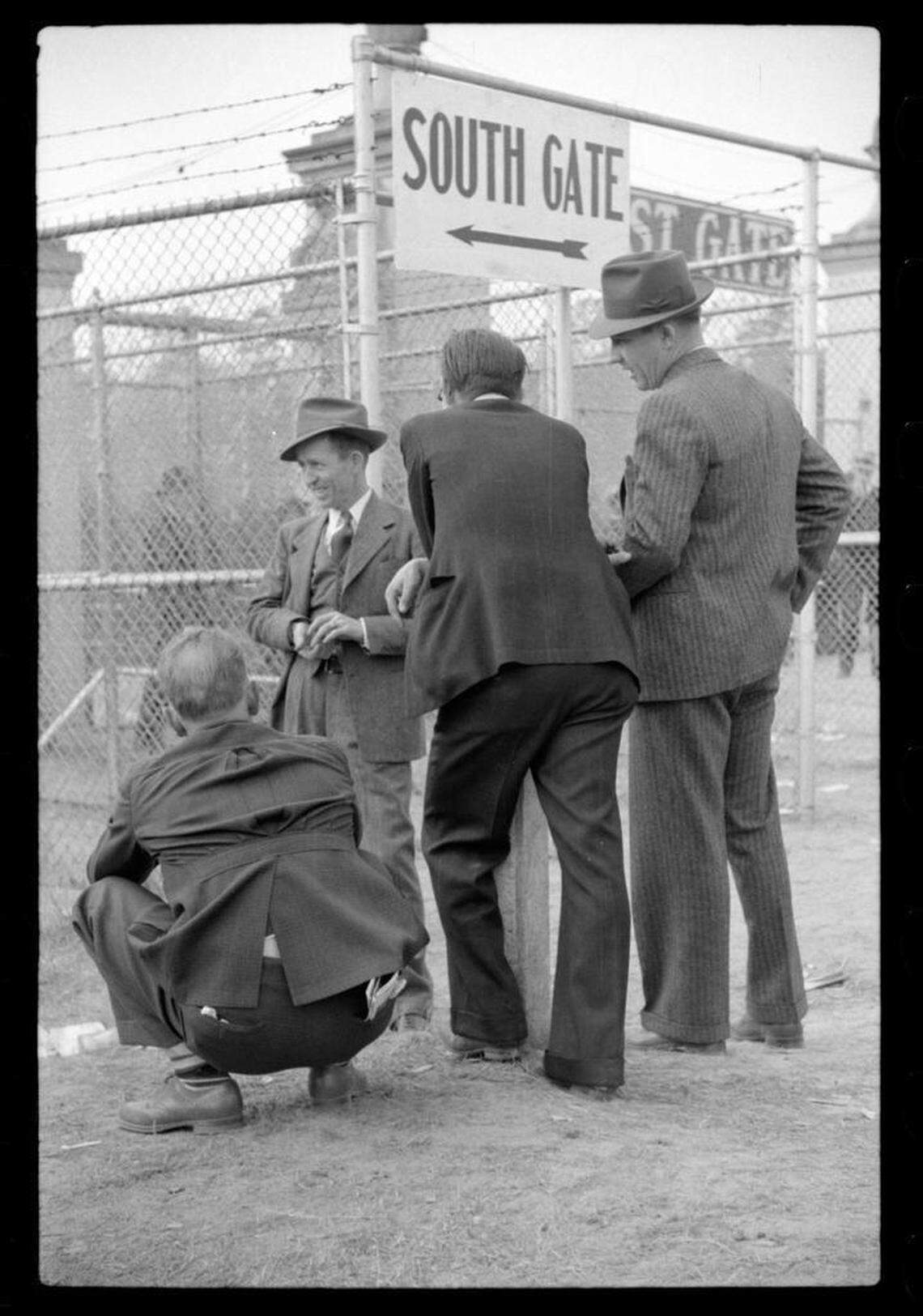 Men who couldn’t get a ticket to the sold-out Duke-Carolina football game in 1939 congregate around a gate to try to get a view of the rivalry game.