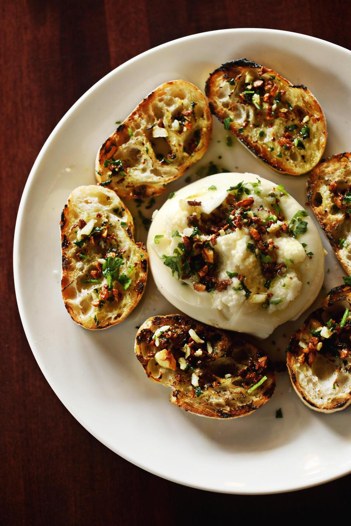 Richard Procida makes burrata in house, and offers it as a starter topped with pine nuts, chopped parsley and a drizzle of olive oil, and served with grilled rounds of baguette.