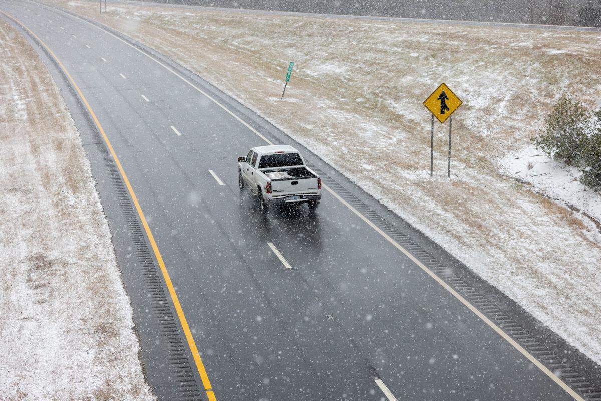 Snow begins stick by mid-afternoon on the grass along US 64, east of Pittsboro, as a winter storm moves through the area on Wednesday, February 19, 2025.
