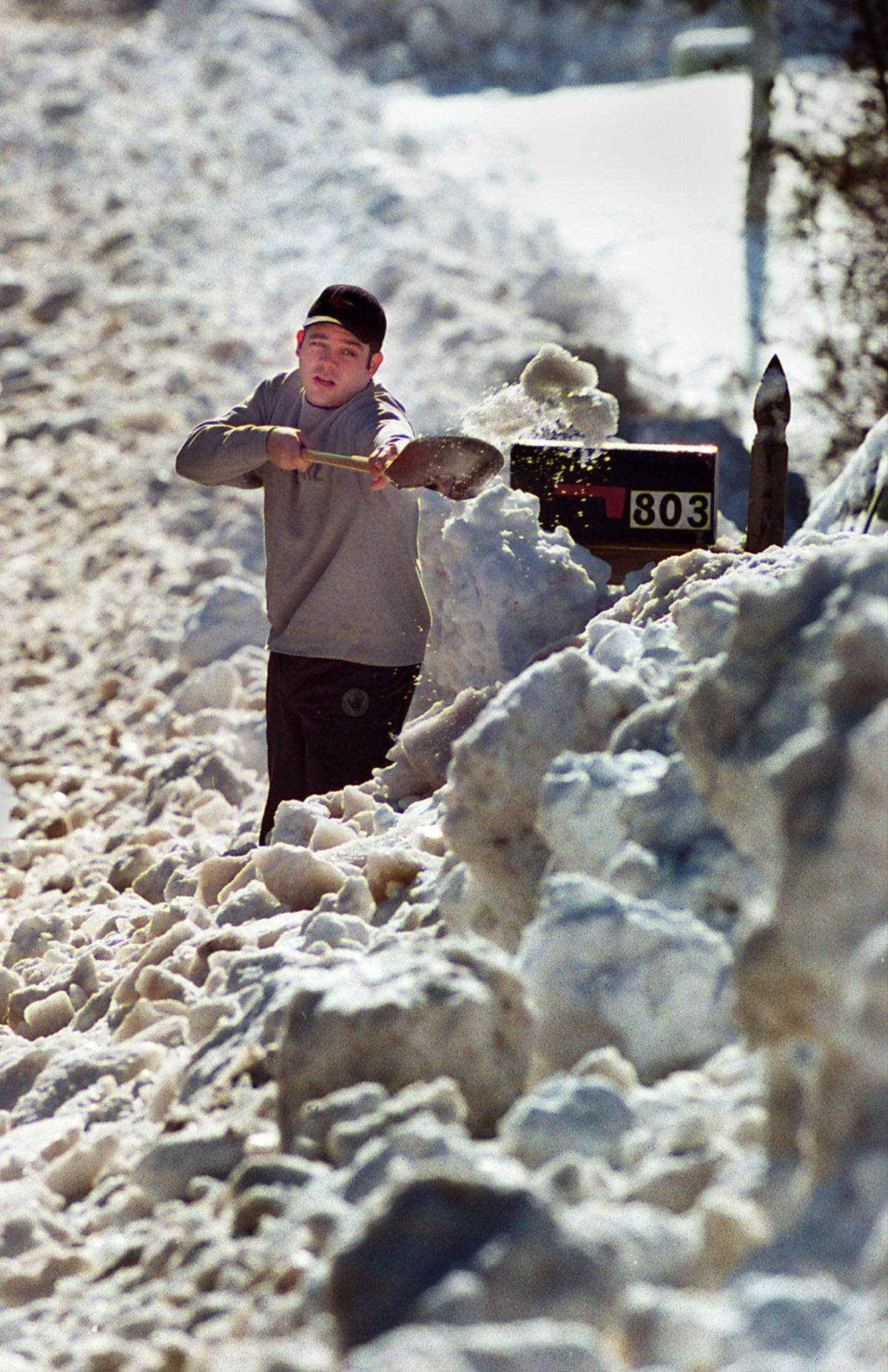 Mike Carlson tries to dig his way through a wall of snow and ice that was plowed in front of his driveway on Maynard Road in Cary in 2000.
