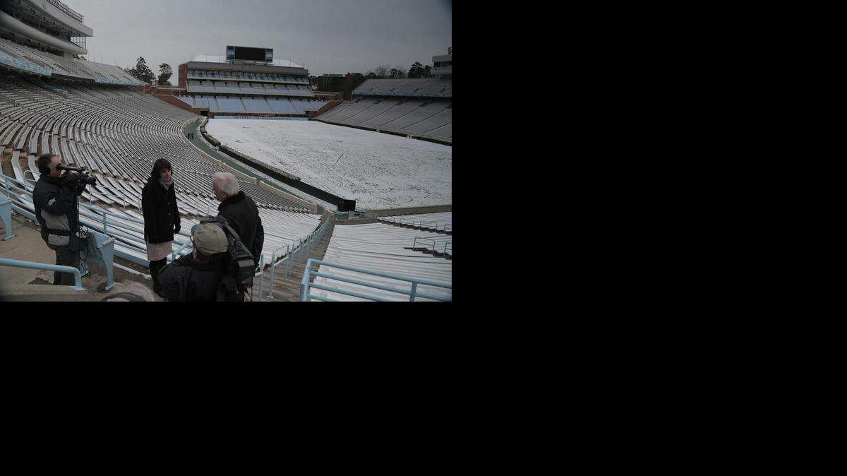 Bernard Goldberg (right) of HBO’s “Real Sports with Bryant Gumbel” interviews Mary Willingham (center), former learning specialist for UNC’s tutoring program for athletes, at Kenan Stadium on the UNC-Chapel Hill campus.
