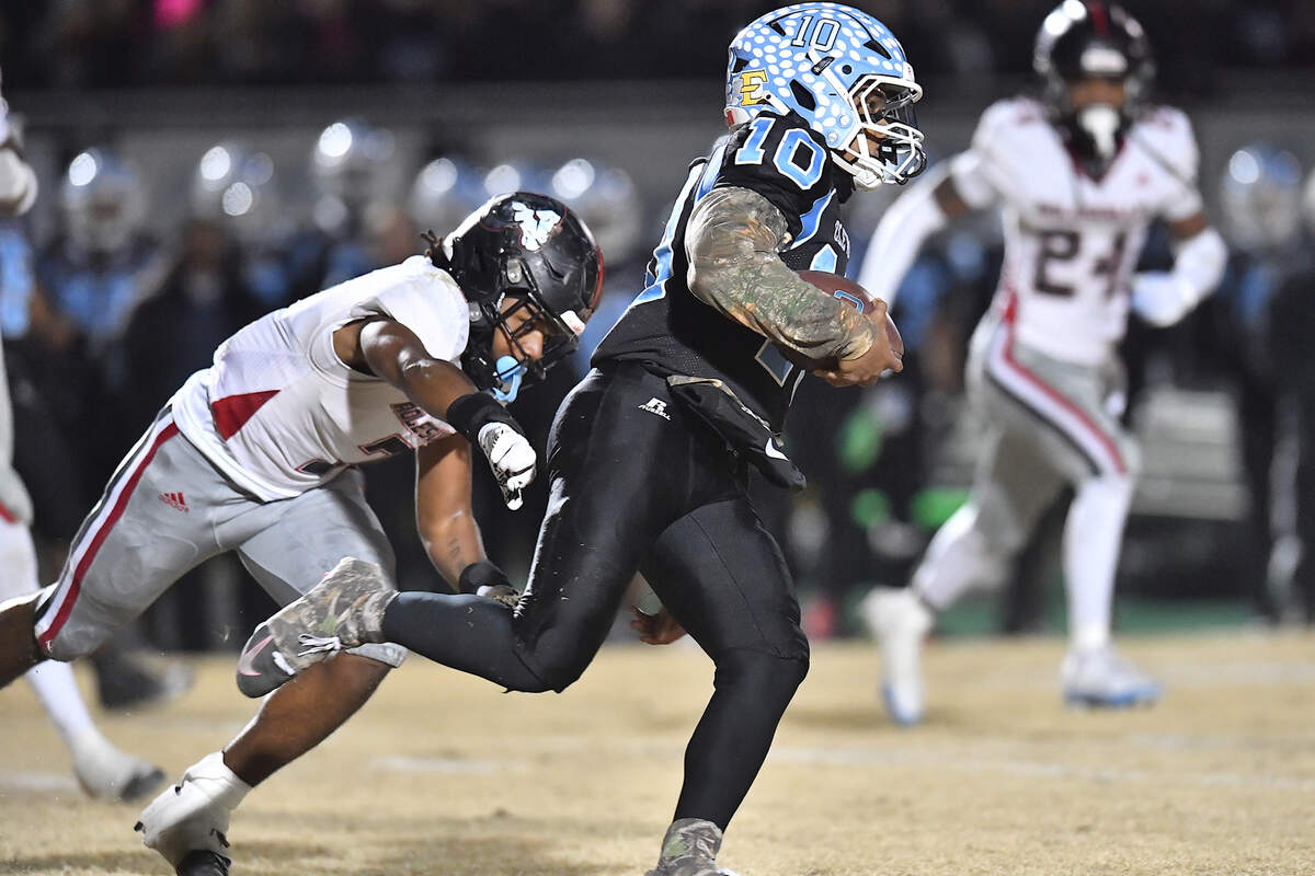 Cleveland quarterback Jackson Byrd (10) runs for the first down ahead of Rolesville’s Avery Fleet (7) during the first half. The Rolesville Rams and the Cleveland Rams met in the fourth round of the NCHSAA 4A football playoffs in Clayton, N.C. on December 6, 2024.
