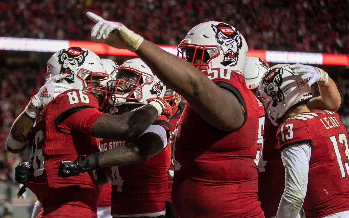 N.C. State’s Emeka Emezie (86) celebrates with teammate Porter Rooks (4) after scoring the game winning touchdown on a 24-yard pass from quarterback Devin Leary with 1:09 to play, give the Wolfpack a 34-30 victory on Friday, November 26, 2021 at Carter-Finley Stadium in Raleigh, N.C.