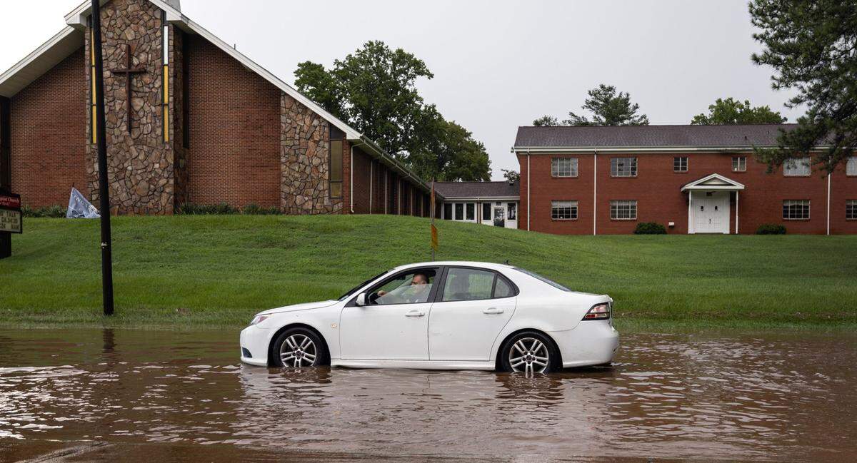 A car sits stalled in a flooded S. Saunders Street after heavy rains in Raleigh, N.C., Sunday, August 4, 2024.