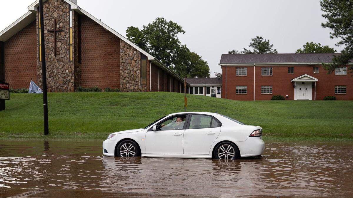 A car sits stalled in a flooded S. Saunders Street after heavy rains in Raleigh, N.C., Sunday, August 4, 2024.
