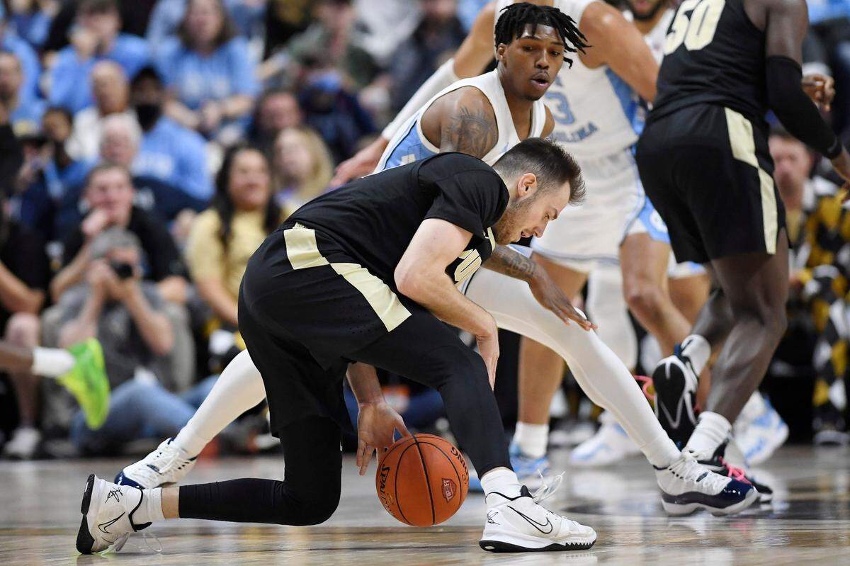 Purdue’s Sasha Stefanovic dribbles the ball as North Carolina’s Caleb Love, back, defends in the first half of an NCAA college basketball game, Saturday, Nov. 20, 2021.