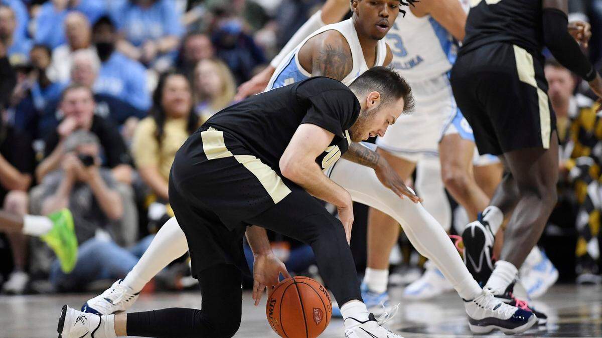 Purdue’s Sasha Stefanovic dribbles the ball as North Carolina’s Caleb Love, back, defends in the first half of an NCAA college basketball game, Saturday, Nov. 20, 2021.